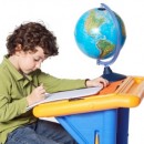 a child studying in front of a globe