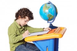 a child studying in front of a globe